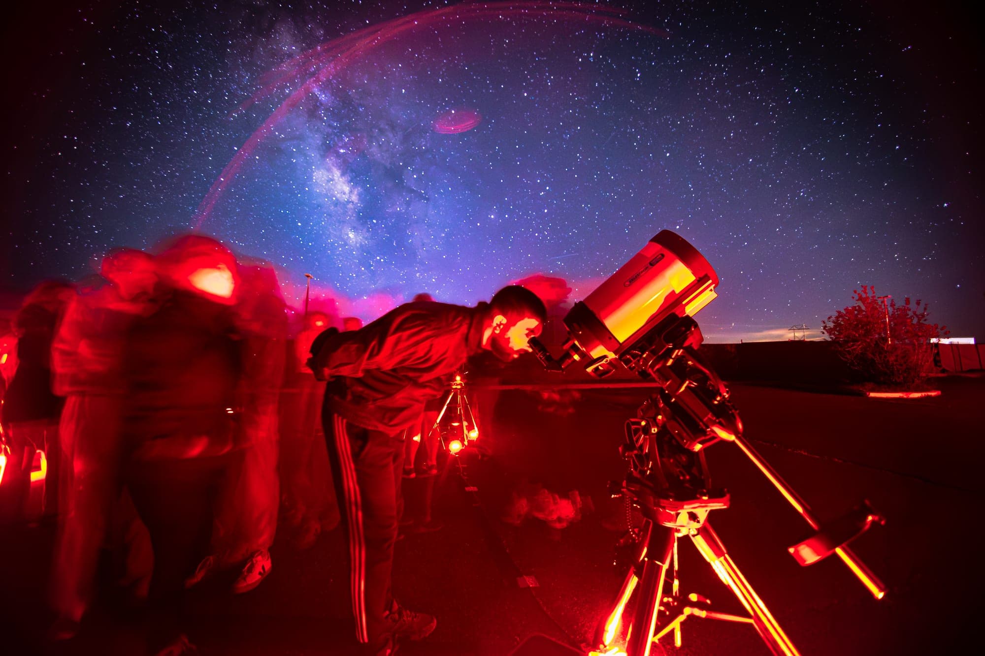 Guests waiting their turn at the telescope under the full arch of the Milky Way