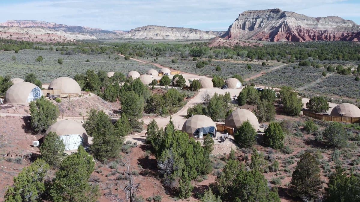 Geodesic dome tents at Bryce Glamp and Camp below red cliffs