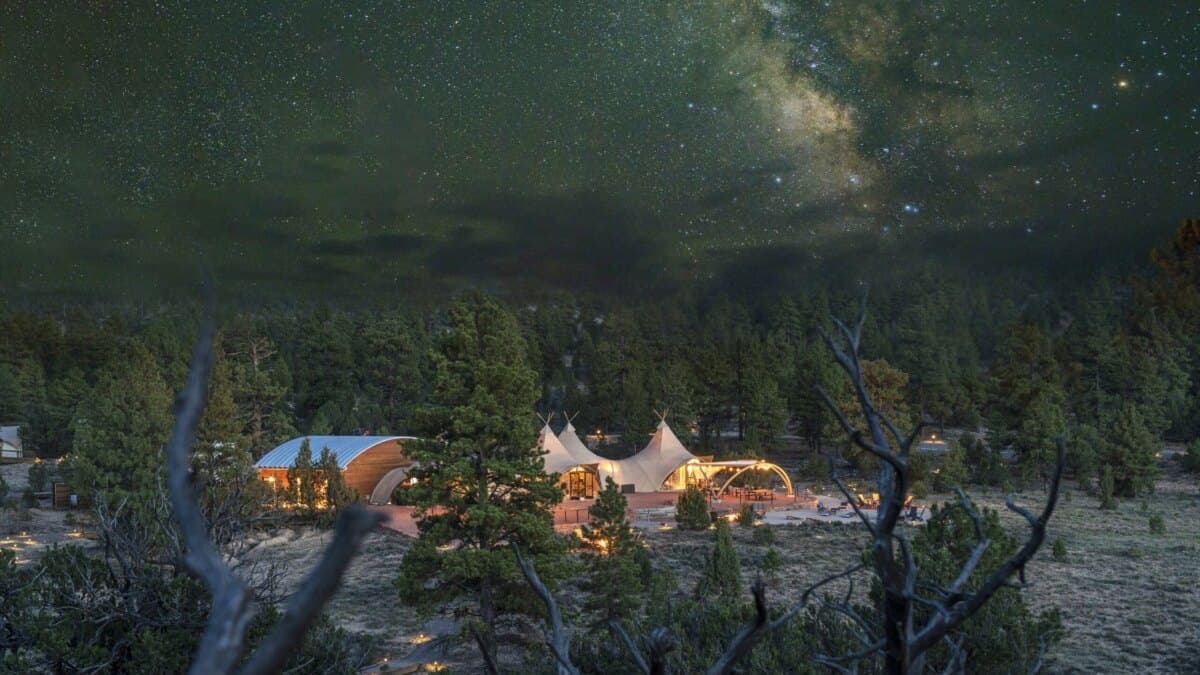 The lit tents of Under Canvas Bryce Canyon under the Milky Way